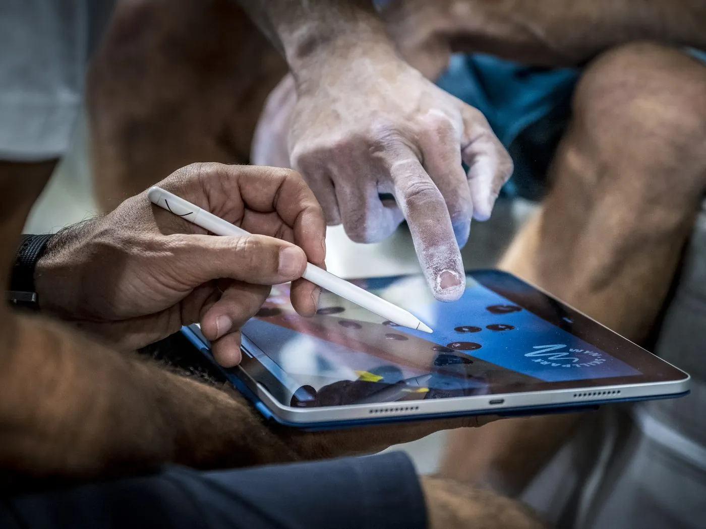 A setter draws a route on a tablet at the foot of the wall